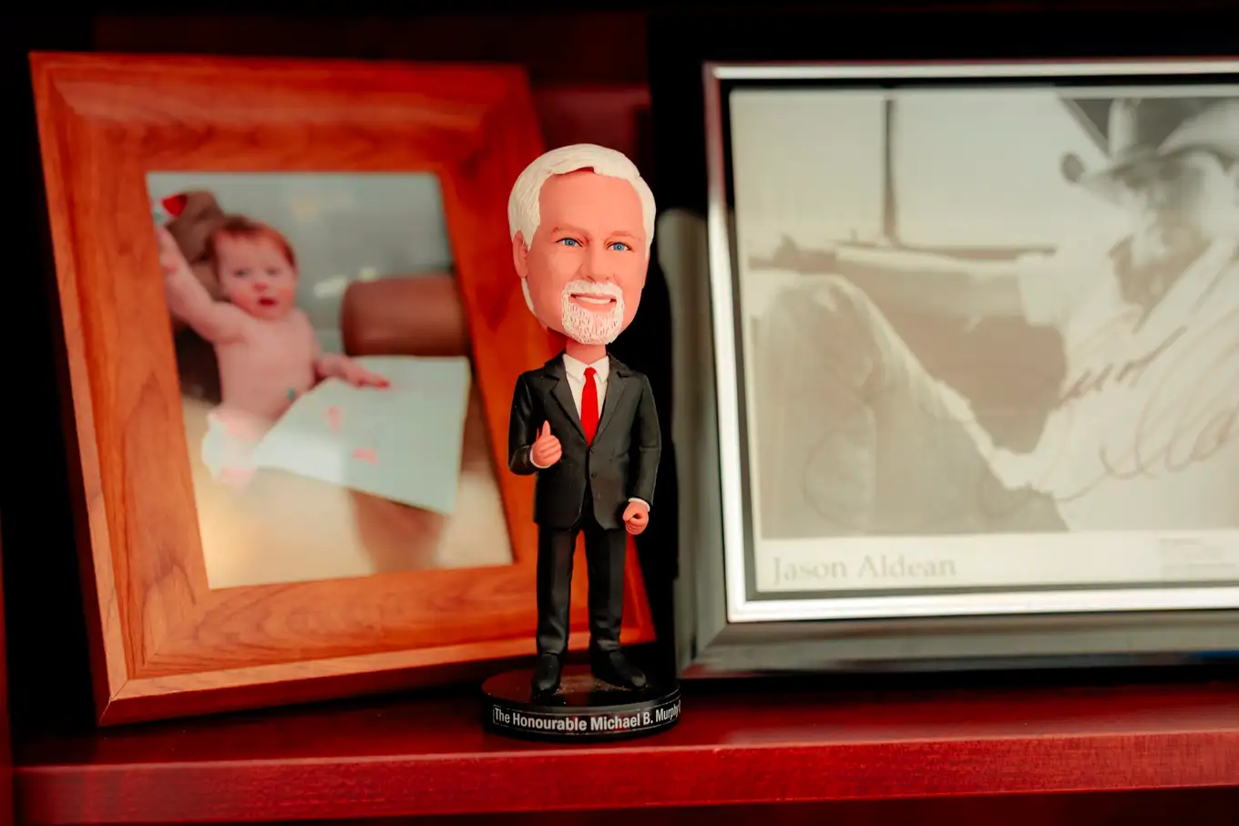 A bobblehead of Michael Murphy, K.C. beside a framed photograph in his office