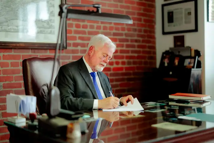 Michael Murphy, c.r., signant un document à son bureau à Moncton