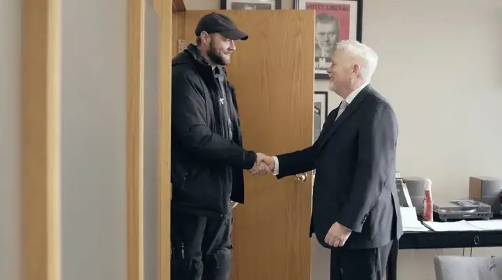 Michael Murphy accueillant un client à la porte du cabinet